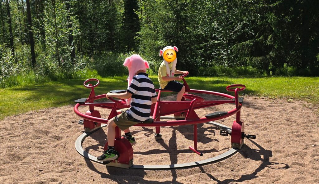 Lapset leikkipuiston pyöräkarusellissa